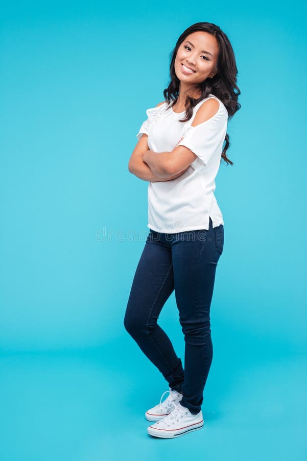 Retrato de una mujer asiática hermosa alegre con los brazos doblados fotografía de archivo libre de regalías Retrato de una mujer asiática hermosa alegre con los brazos doblados fotografía de archivo libre de regalías