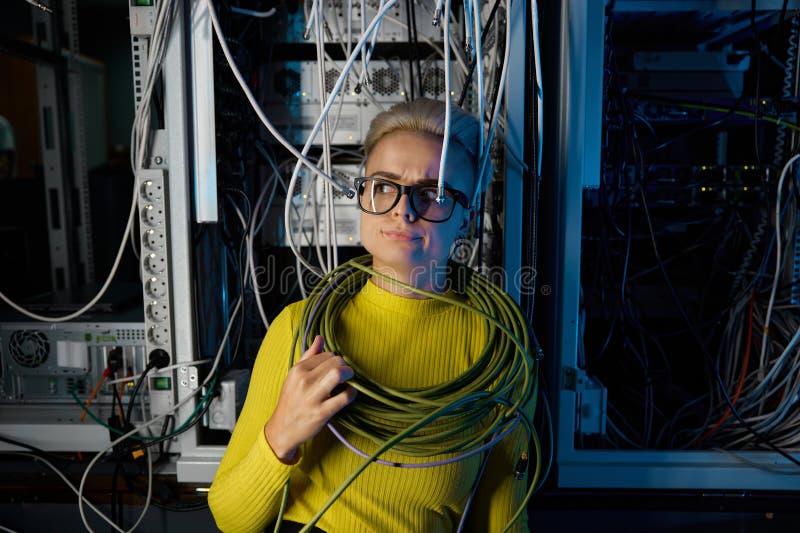 Retrato de una mujer cansada y abrumada ingeniera de tecnología informática en la sala de servidores imagenes de archivo