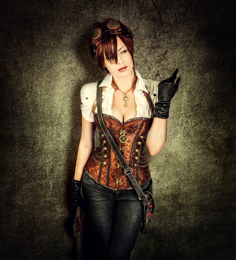 Portrait of a beautiful steampunk woman wearing vintage corset and retro goggles on old grange background. Portrait of a beautiful steampunk woman wearing vintage corset and retro goggles on old grange background