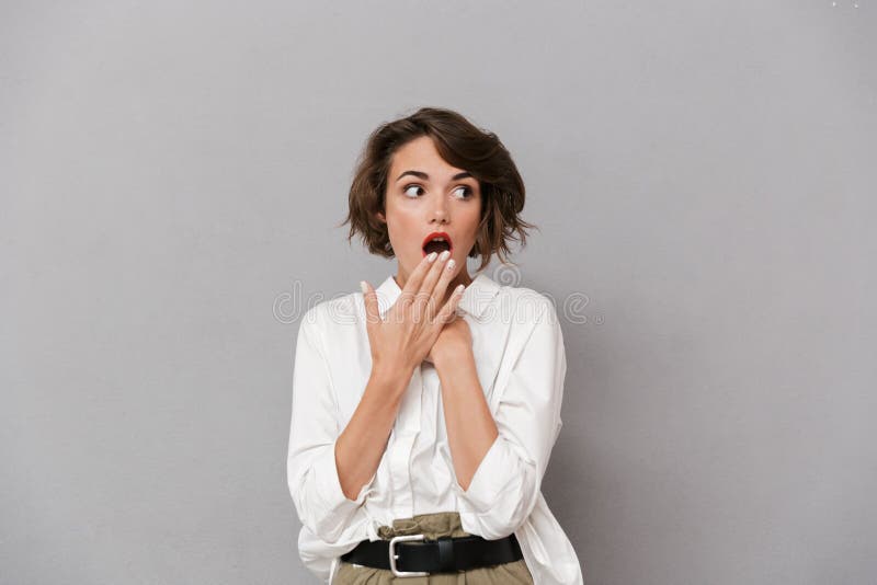 Retrato de una mujer joven chocada vestida en la camisa blanca imagenes de archivo Retrato de una mujer joven chocada vestida en la camisa blanca imagenes de archivo