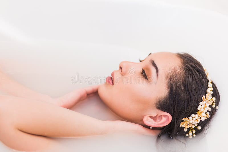 Retrato de una mujer joven en el bathtube, muchacha del primer que se relaja foto de archivo Retrato de una mujer joven en el bathtube, muchacha del primer que se relaja foto de archivo