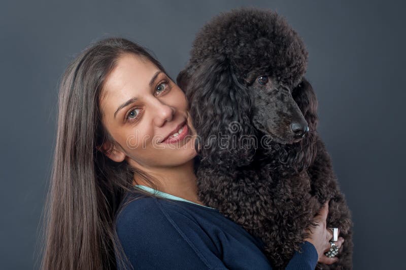 Retrato de una mujer joven hermosa que abraza su perro hermoso imagen de archivo Retrato de una mujer joven hermosa que abraza su perro hermoso imagen de archivo