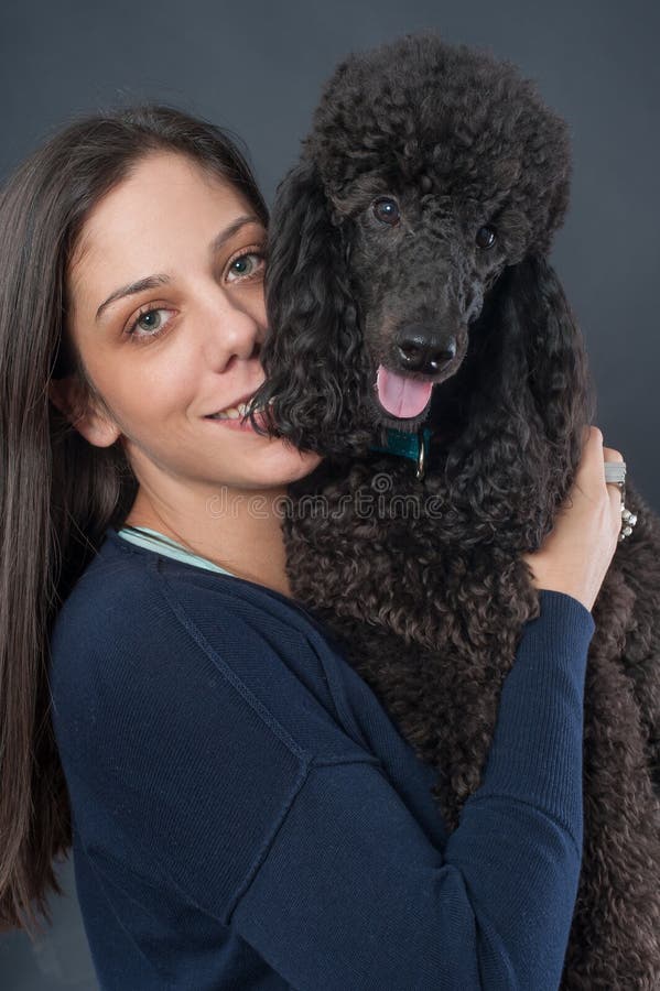 Retrato de una mujer joven hermosa que abraza su perro hermoso fotografía de archivo Retrato de una mujer joven hermosa que abraza su perro hermoso fotografía de archivo