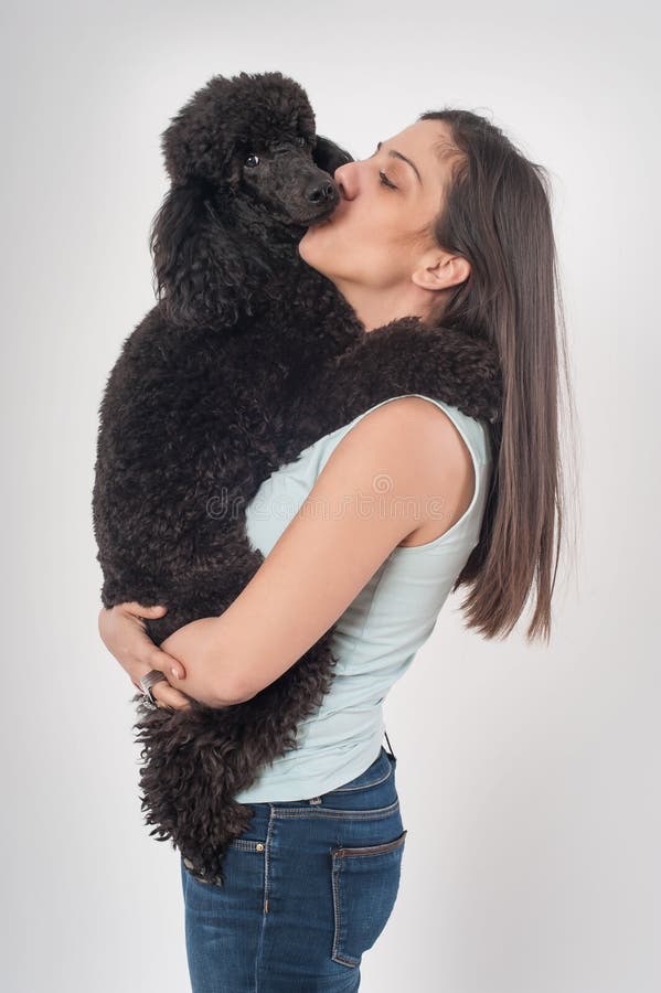 Retrato de una mujer joven hermosa que besa su perro hermoso imágenes de archivo libres de regalías Retrato de una mujer joven hermosa que besa su perro hermoso imágenes de archivo libres de regalías