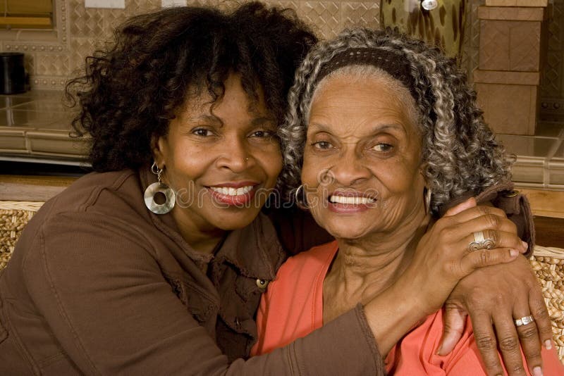 Retrato de una mujer mayor que abraza a su hija imagenes de archivo
