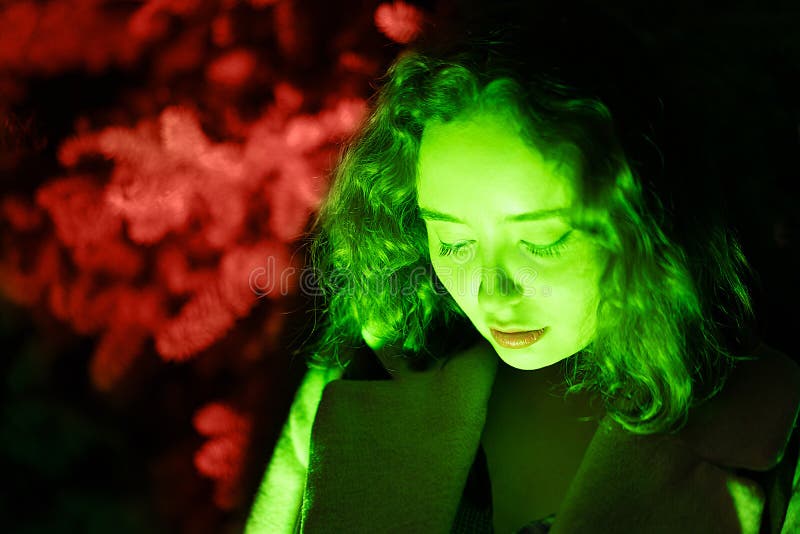 Retrato de una mujer misteriosa en la iluminación verde con el fondo coralino foto de archivo Retrato de una mujer misteriosa en la iluminación verde con el fondo coralino foto de archivo