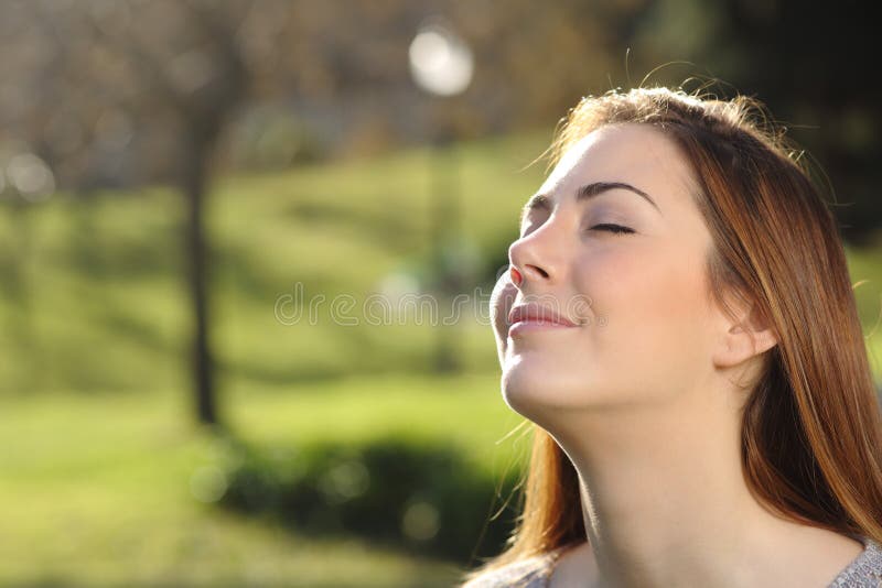 Retrato de una mujer relajada que respira profundamente en un parque foto de archivo Retrato de una mujer relajada que respira profundamente en un parque foto de archivo
