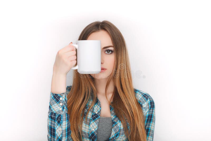 Retrato de una mujer rubia adorable joven en camisa de tela escocesa azul que disfruta de su bebida acogedora caliente en taza bl imagen de archivo libre de regalías Retrato de una mujer rubia adorable joven en camisa de tela escocesa azul que disfruta de su bebida acogedora caliente en taza bl imagen de archivo libre de regalías