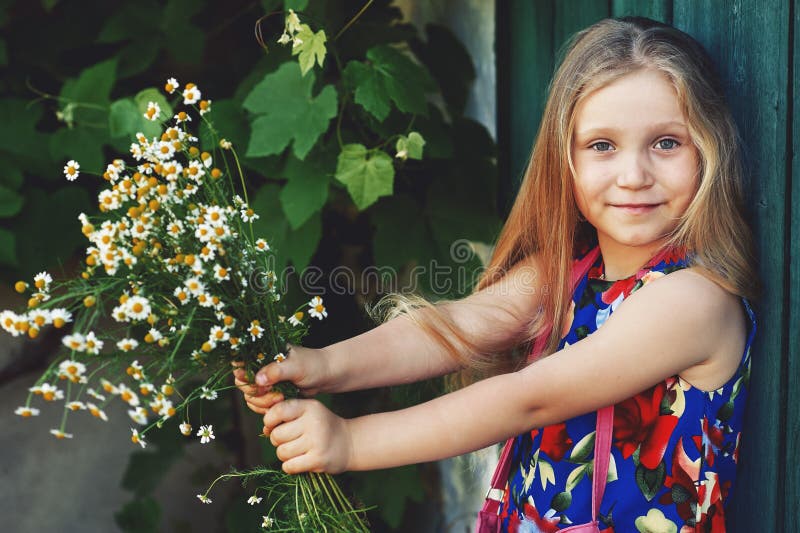 Retrato de una niña con las margaritas Bebé precioso con las flores fotos de archivo Retrato de una niña con las margaritas Bebé precioso con las flores fotos de archivo