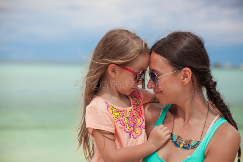 Retrato de una niña que abraza con su madre imagen de archivo Retrato de una niña que abraza con su madre imagen de archivo