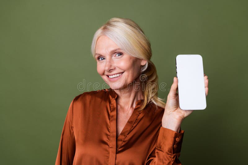 Portrait of toothy beaming positive person with blond hair wear blouse show menu on smartphone display isolated on khaki color background. Portrait of toothy beaming positive person with blond hair wear blouse show menu on smartphone display isolated on khaki color background.