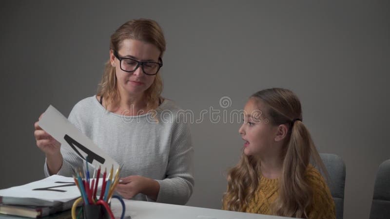 Retrato de una profesora caucásica en anteojos y alfabeto para niñas aprendiendo Muestra inteligente de jóvenes profesores