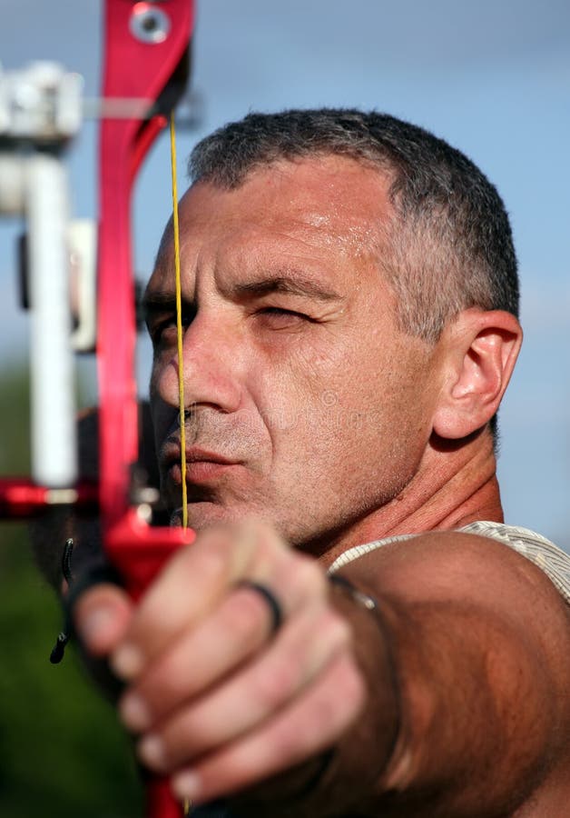 Portrait of professional bowman aiming with bow and arrow. Portrait of professional bowman aiming with bow and arrow