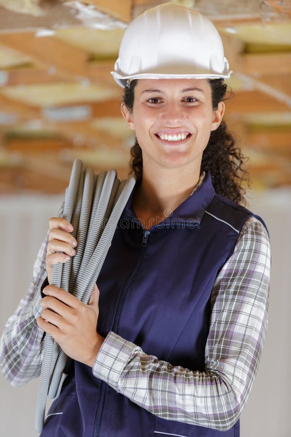 Retrato del carrete del cable del trabajador femenino sobre el hombro imagenes de archivo