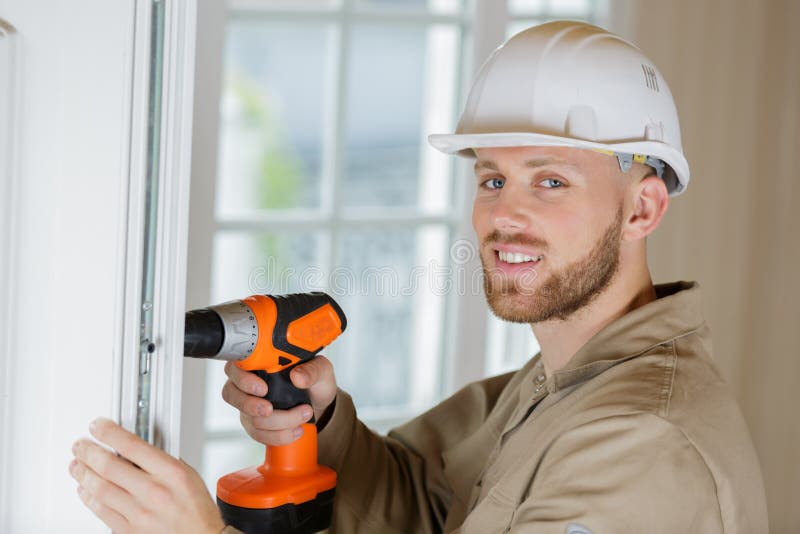 Retrato del constructor masculino usando taladro inalámbrico fotos de archivo libres de regalías