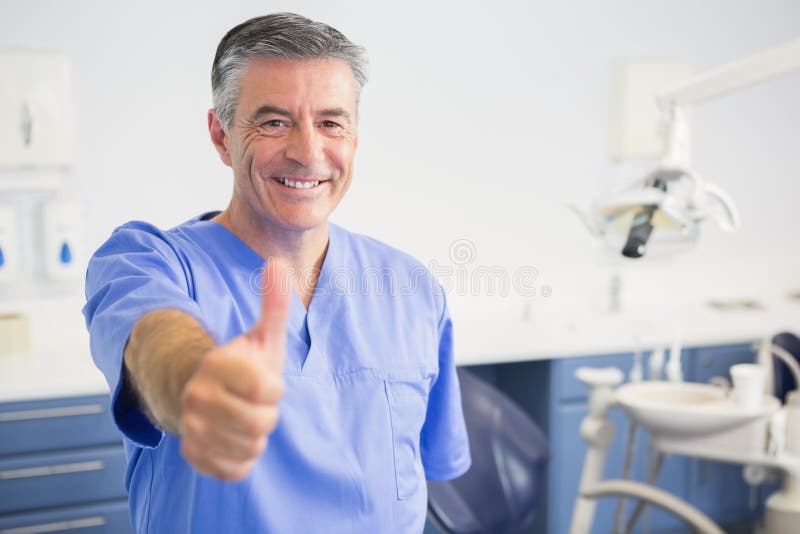 Retrato del dentista feliz con los pulgares para arriba