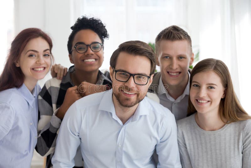 Retrato del equipo milenario diverso sonriente que presenta junto foto de archivo Retrato del equipo milenario diverso sonriente que presenta junto foto de archivo