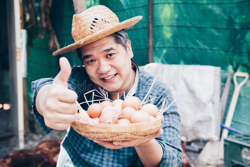 Retrato del granjero bueno amistoso hermoso satisfecho del júbilo delicioso trabajador emocionado que sostiene la pequeña cesta foto de archivo Retrato del granjero bueno amistoso hermoso satisfecho del júbilo delicioso trabajador emocionado que sostiene la pequeña cesta foto de archivo