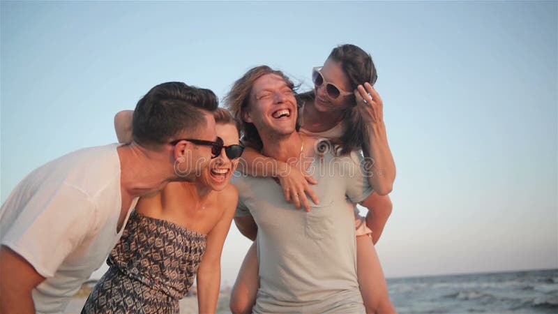 Retrato del grupo de personas joven feliz que disfruta de día de fiesta de la playa Cuatro amigos están riendo cerca del mar dura