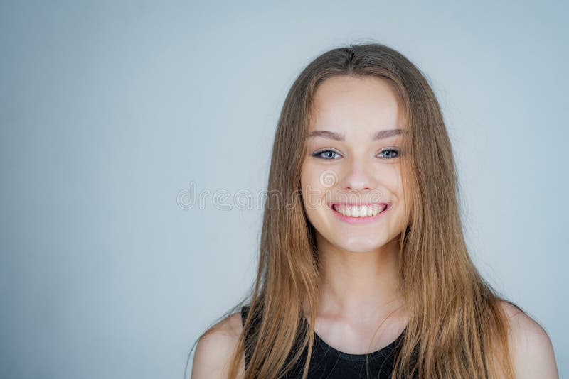 Headshot Portrait of happy girl with beauty face smiling looking at camera. Pretty smiling joyfully female with fair hair - dressed casually. Headshot Portrait of happy girl with beauty face smiling looking at camera. Pretty smiling joyfully female with fair hair - dressed casually