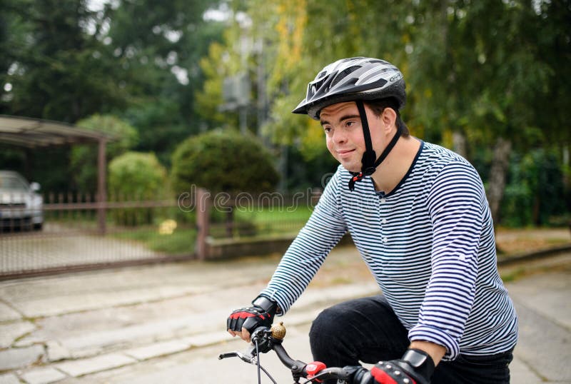 retrato-del-hombre-adulto-con-s%C3%ADndrome-de-down-bicicletas-que-termina-un-ciclo-al-aire-libre-en-la-calle-201398212.jpg