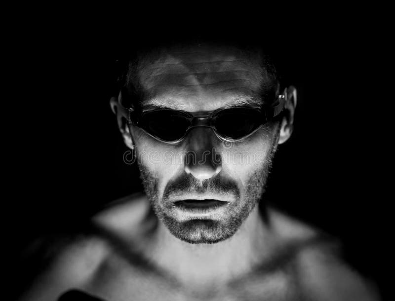 Retrato del hombre caucásico adulto sin afeitar en vidrios que nadan Él sonríe como maniaco y parece como locura Tiro blanco y ne fotografía de archivo