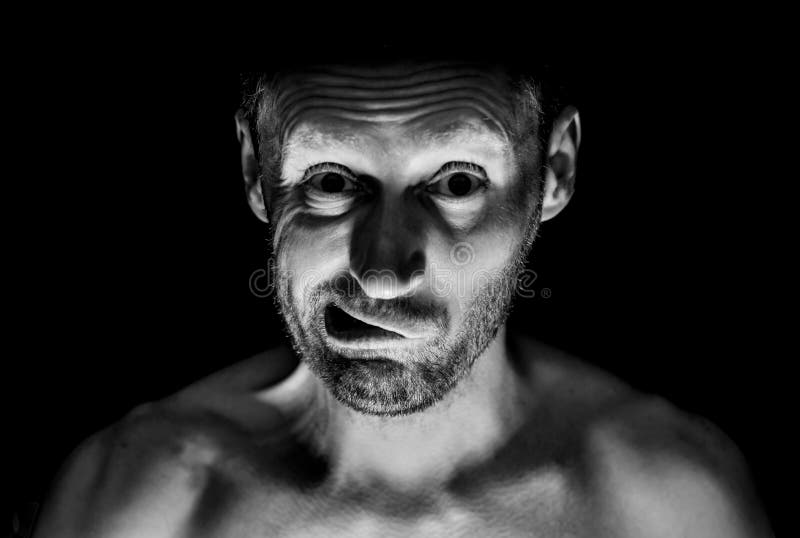 Retrato del hombre caucásico adulto sin afeitar Él sonríe como maniaco y parece como locura Tiro blanco y negro, iluminación disc fotos de archivo