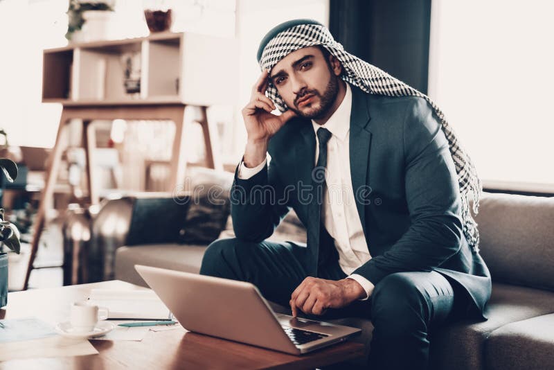 Retrato del hombre de negocios árabe que se sienta en el sofá fotos de archivo