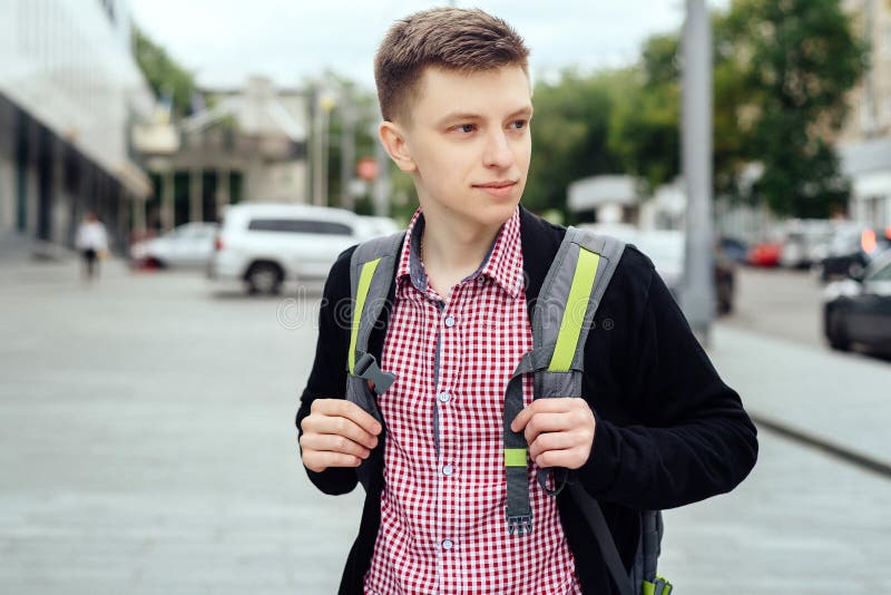 Retrato del hombre joven elegante en camisa y chaqueta de tela escocesa con la mochila que camina en la ciudad al aire libre Mens foto de archivo libre de regalías Retrato del hombre joven elegante en camisa y chaqueta de tela escocesa con la mochila que camina en la ciudad al aire libre Mens foto de archivo libre de regalías