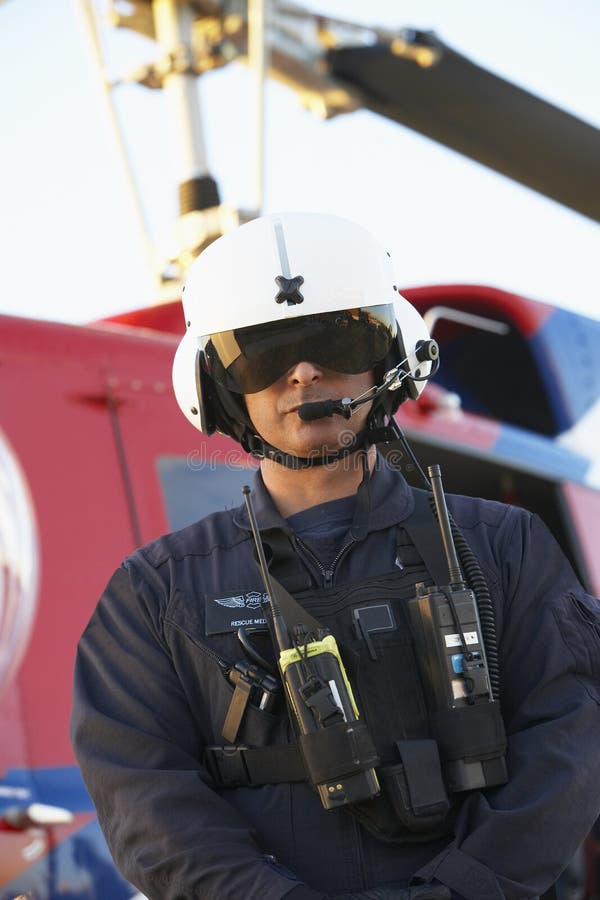 Retrato del paramédico que se coloca delante de helicóptero sanitario del ejército fotos de archivo libres de regalías Retrato del paramédico que se coloca delante de helicóptero sanitario del ejército fotos de archivo libres de regalías