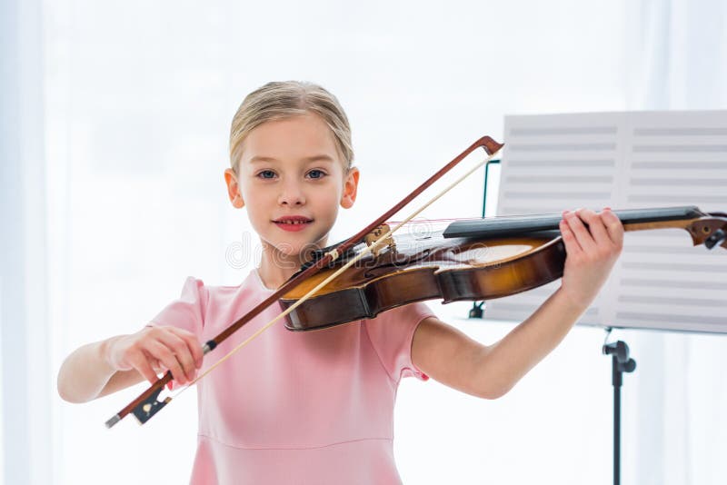 retrato del pequeño niño lindo en el vestido rosado que toca el violín imágenes de archivo libres de regalías retrato del pequeño niño lindo en el vestido rosado que toca el violín imágenes de archivo libres de regalías