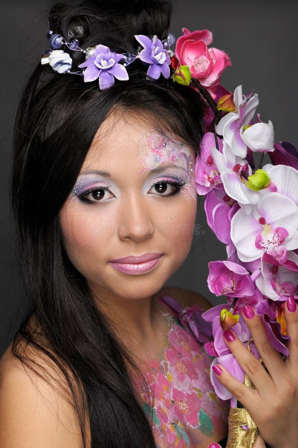 Retrato del primer de la muchacha asiática con las flores imagen de archivo libre de regalías Retrato del primer de la muchacha asiática con las flores imagen de archivo libre de regalías