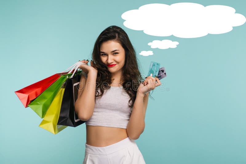 Retrato del primer de la mujer hermosa joven feliz que sostiene la tarjeta de crédito y de los bolsos de compras, mirando la cáma fotografía de archivo Retrato del primer de la mujer hermosa joven feliz que sostiene la tarjeta de crédito y de los bolsos de compras, mirando la cáma fotografía de archivo