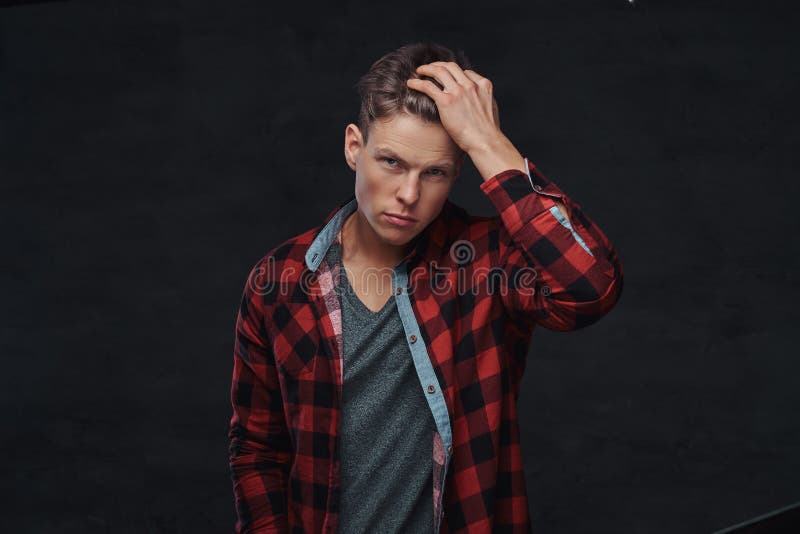 Retrato del primer de un hombre joven hermoso en una camisa del paño grueso y suave, presentando en un estudio imagen de archivo libre de regalías Retrato del primer de un hombre joven hermoso en una camisa del paño grueso y suave, presentando en un estudio imagen de archivo libre de regalías