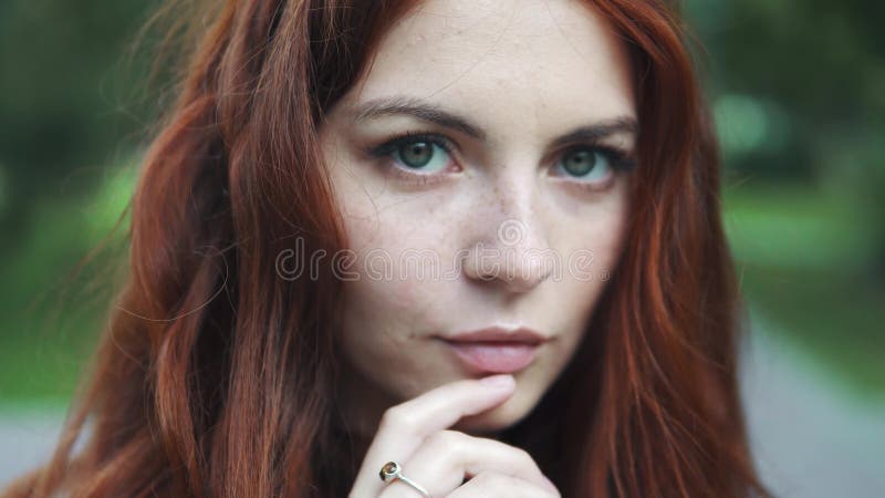 Retrato del primer de una muchacha pelirroja hermosa con los ojos expresivos almacen de metraje de vídeo