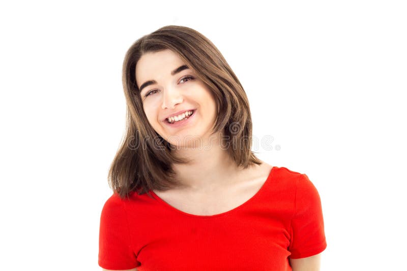 Retrato del primer de una muchacha sonriente feliz joven en camiseta roja contra el fondo, la forma de vida y el concepto blancos foto de archivo libre de regalías Retrato del primer de una muchacha sonriente feliz joven en camiseta roja contra el fondo, la forma de vida y el concepto blancos foto de archivo libre de regalías