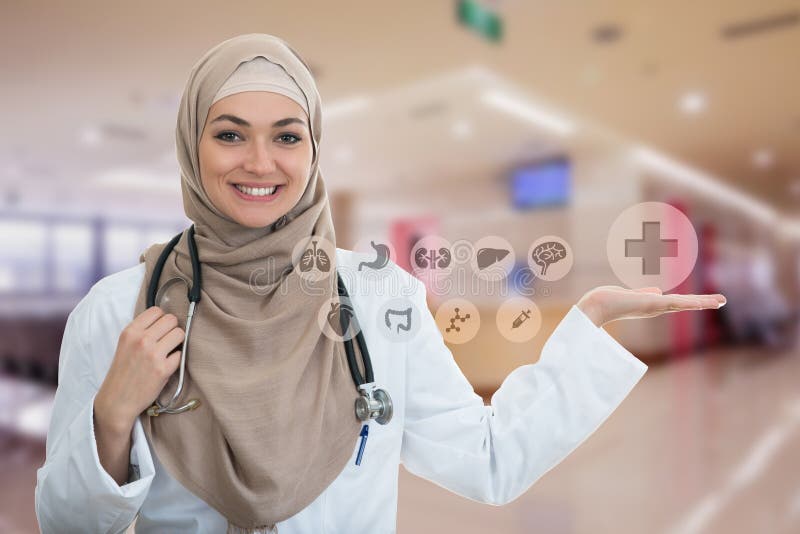 Retrato del primer del doctor de sexo femenino musulmán confiado amistoso, sonriente que lleva a cabo símbolos médicos imagen de archivo libre de regalías Retrato del primer del doctor de sexo femenino musulmán confiado amistoso, sonriente que lleva a cabo símbolos médicos imagen de archivo libre de regalías