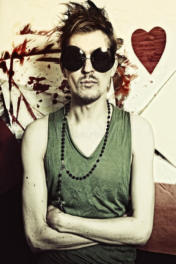 Retrato del punky joven en gafas de sol redondas foto de archivo Retrato del punky joven en gafas de sol redondas foto de archivo
