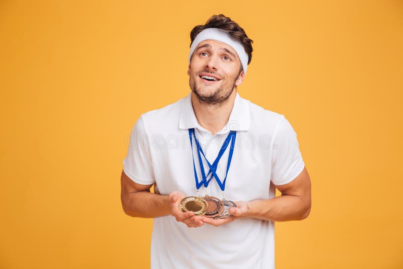 Retrato del spotrsman joven sonriente con tres medallas fotografía de archivo Retrato del spotrsman joven sonriente con tres medallas fotografía de archivo