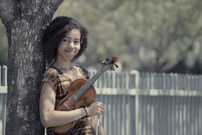 Retrato desvanecido da jovem mulher que guarda o violino fora foto de stock Retrato desvanecido da jovem mulher que guarda o violino fora foto de stock
