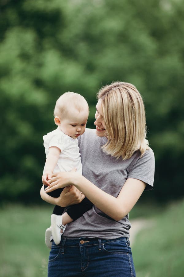 Retrato do bebê bonito que abraça com a mãe de sorriso nova alegre imagens de stock Retrato do bebê bonito que abraça com a mãe de sorriso nova alegre imagens de stock