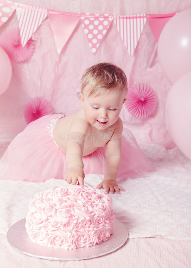 Retrato do bebê caucasiano adorável bonito com olhos azuis na saia cor-de-rosa do tutu que comemora seu primeiro aniversário com fotografia de stock royalty free Retrato do bebê caucasiano adorável bonito com olhos azuis na saia cor-de-rosa do tutu que comemora seu primeiro aniversário com fotografia de stock royalty free