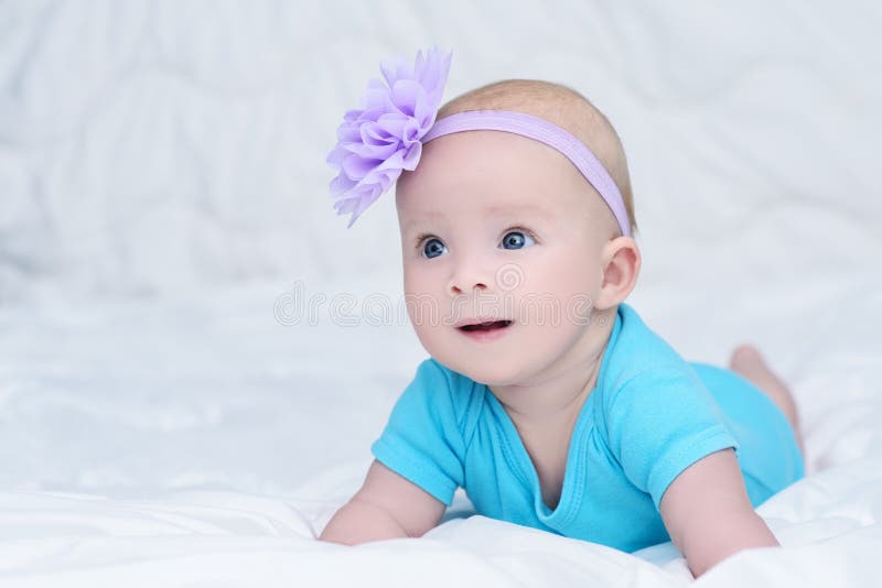 Retrato do bebê pequeno bonito com a flor da curva em sua cabeça fotos de stock Retrato do bebê pequeno bonito com a flor da curva em sua cabeça fotos de stock