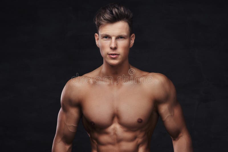 Retrato do close-up de um modelo descamisado 'sexy' do homem novo com um corpo muscular e um corte de cabelo à moda que levantam imagem de stock Retrato do close-up de um modelo descamisado 'sexy' do homem novo com um corpo muscular e um corte de cabelo à moda que levantam imagem de stock