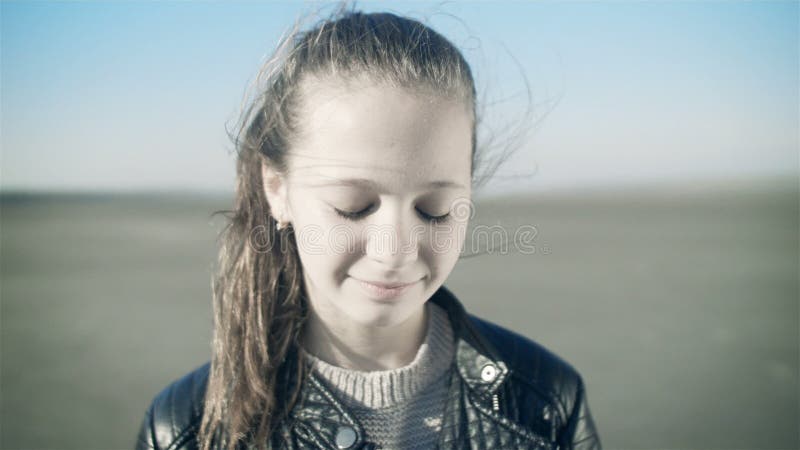 Retrato do close-up de uma menina de sorriso nova Uma menina doce olha a câmera e ri