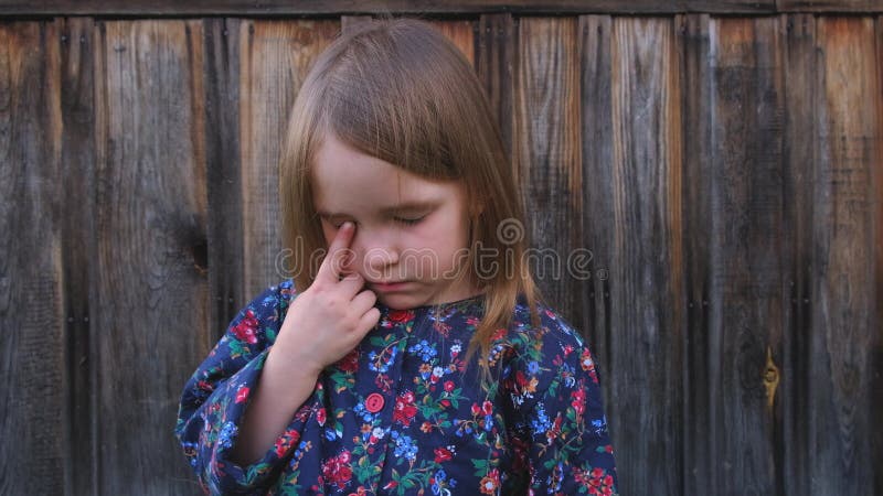 Retrato do close-up de uma menina triste em um revestimento da flor