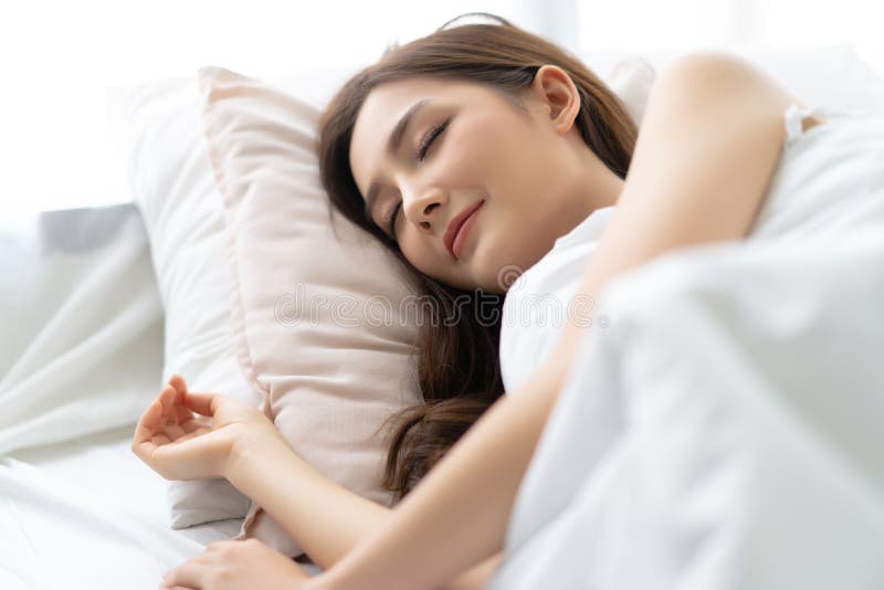 Retrato do close up de uma mulher asiática bonita nova calma que dorme em sua cama e que relaxa na manhã Senhora que aprecia sonh foto de stock royalty free Retrato do close up de uma mulher asiática bonita nova calma que dorme em sua cama e que relaxa na manhã Senhora que aprecia sonh foto de stock royalty free