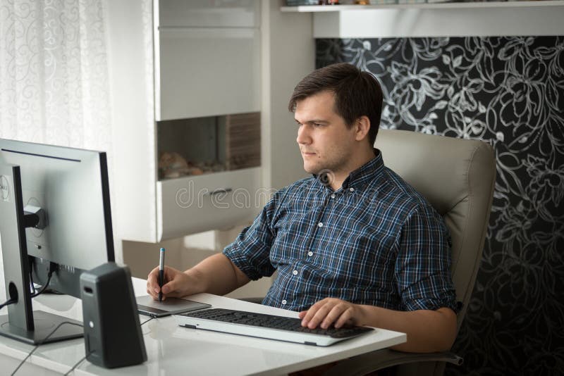 Retrato do designer gráfico masculino novo que trabalha em casa o escritório com tabuleta gráfica fotografia de stock Retrato do designer gráfico masculino novo que trabalha em casa o escritório com tabuleta gráfica fotografia de stock