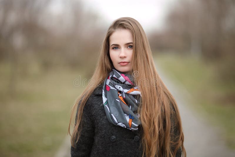Retrato do estilo de vida da mulher adulta nova e bonita com o cabelo longo lindo que levanta no parque da cidade com profundidad fotos de stock Retrato do estilo de vida da mulher adulta nova e bonita com o cabelo longo lindo que levanta no parque da cidade com profundidad fotos de stock