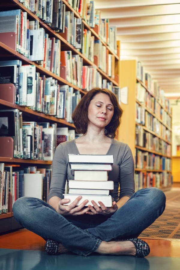 Retrato do estudante de mulher maduro da Idade Média cansado que senta-se na biblioteca com os olhos fechados que meditam, dormin fotos de stock royalty free Retrato do estudante de mulher maduro da Idade Média cansado que senta-se na biblioteca com os olhos fechados que meditam, dormin fotos de stock royalty free